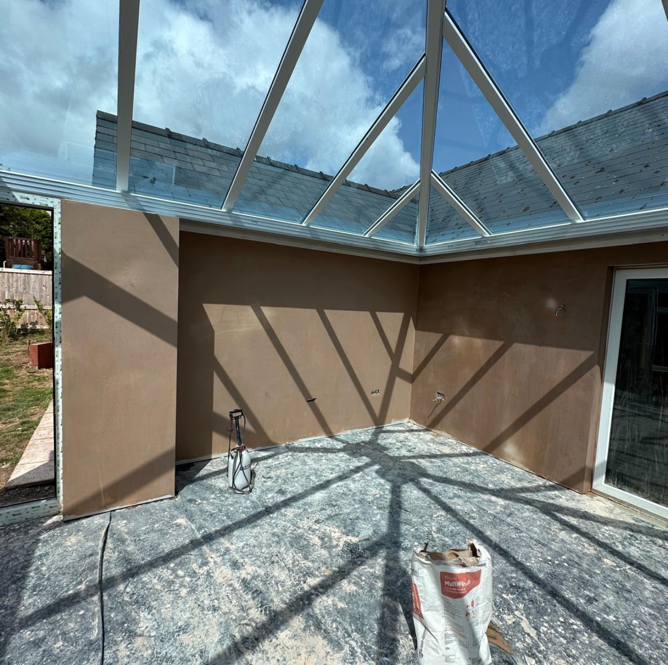 Plastered conservatory walls under a glass roof