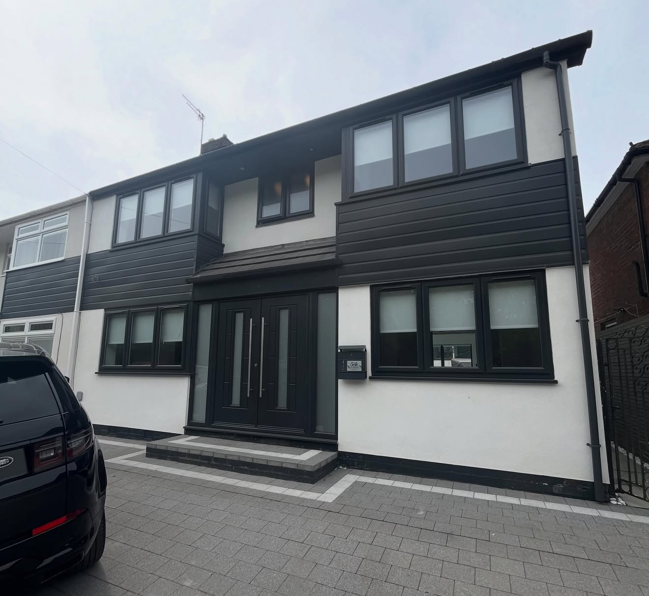 Rendered house front with dark cladding