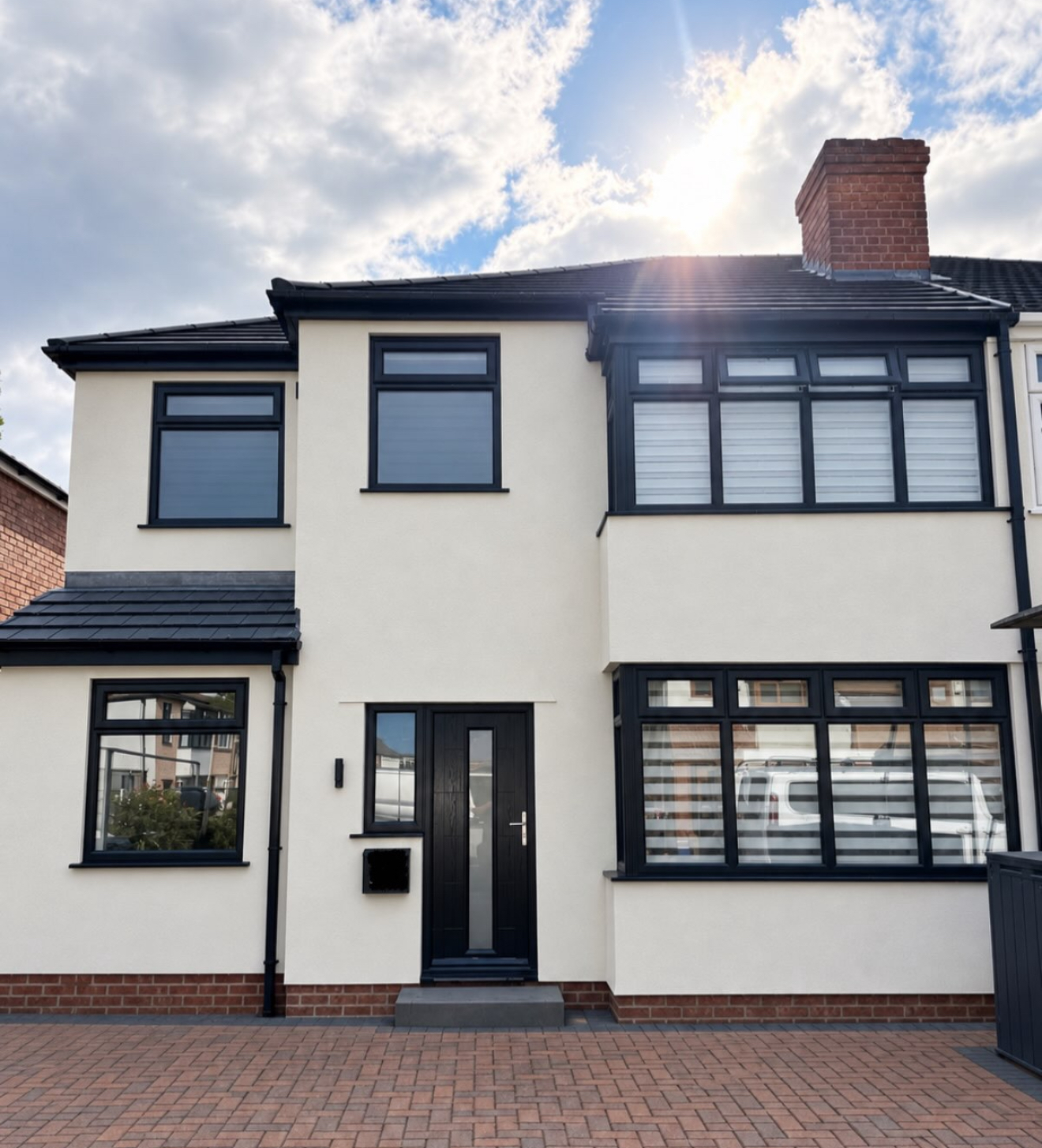 Rendered house front with a brick driveway