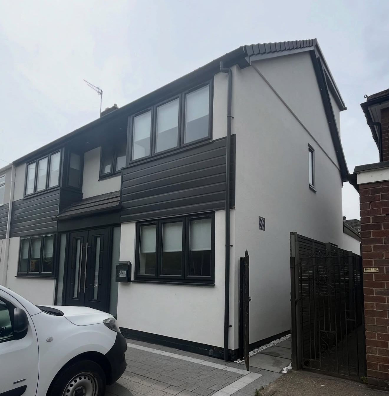 Rendered side of a house with dark cladding